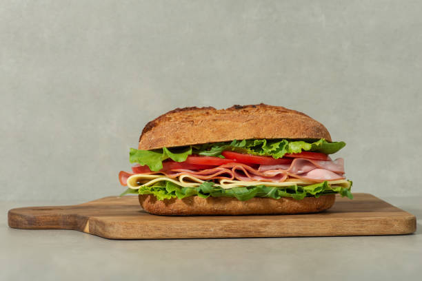 istock Sandwich with mortadella, cheese and tomatoes on a gray table 1495346206