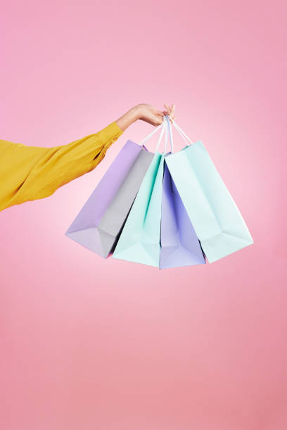 Shopping bag, studio and hands of woman, person or female with retail sales product, discount deal or mall store present. Market choice purchase, luxury designer gift and customer on pink background bolsa de compras, estudio y manos de mujer, persona o mujer con producto de venta minorista, oferta de descuento o tienda de centro comercial presente. compra de elección de mercado, regalo de diseñador de lujo y cliente sobre fondo rosa