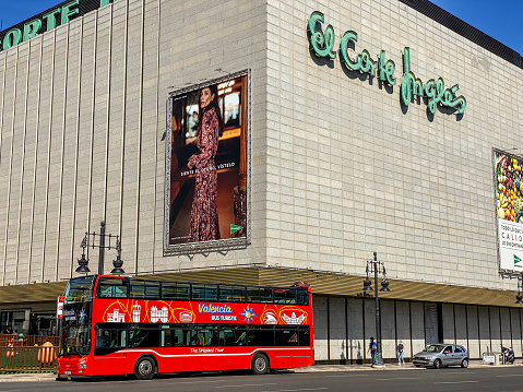 Valencia, Spain - October 5, 2020: Red tour bus parked in front of shopping mall waiting for people to hop in. This service makes a circuit around the city letting tourists to know it in a very short amount of time