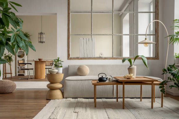 istock Open space interior with modular sofa, wooden coffee table, big window, beige rug, round pillow, stylish table, lamp, plants, vase with leaves and personal accessories. Home decor. Template. 1495354664