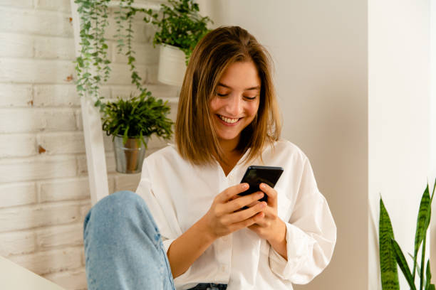 istock Young woman using her mobile phone 1495354768