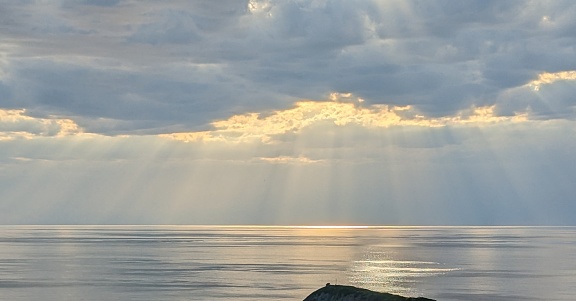 Sunbeams shine over waters by the town of Shari on the Shiretoko Peninsula in northeast Hokkaido. View looking north to Sea of Okhotsk. Spring afternoon.