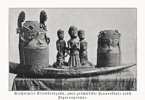 Carved ivory tooth, two decorated women's heads and group of figures - components of looted art (Benin bronzes), which were sold to Germany, among others, in the course of the colonization of Africa by the United Kingdom in 1897. The Benin Bronzes are a group of several thousand metal plaques and sculptures that decorated the royal palace of the Kingdom of Benin, in what is now Edo State, Nigeria. Collectively, the objects form the best examples of Benin art and were created from the thirteenth century by artists of the Edo people. In addition to their great art-historical importance, they also play an important role in the international discussion about the return of cultural property of colonial origin.  Halftone print after a photograph, published in 1899.