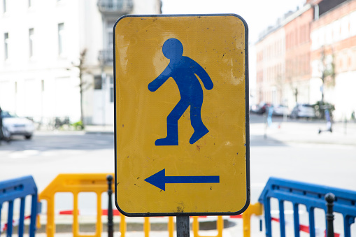 Pedestrians crossing warning sign black symbols on white background