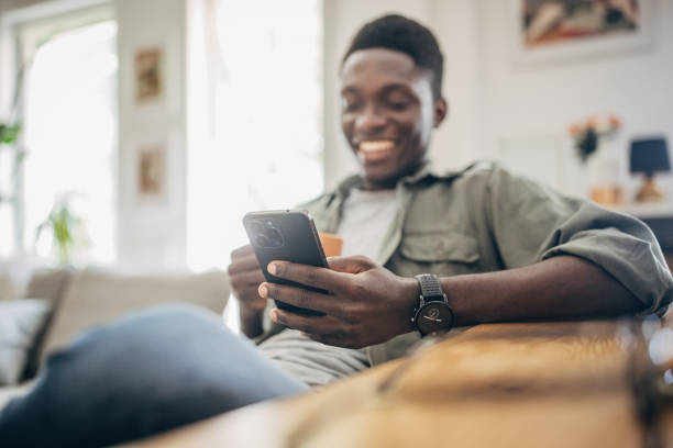 istock Young man relaxing at home and using mobile phone 1495359964