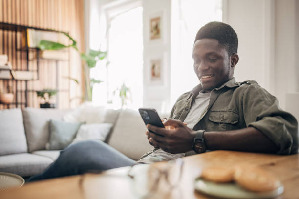 istock Young man relaxing at home and using mobile phone 1495360059