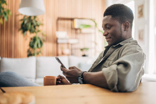 istock Young man relaxing at home and using mobile phone 1495360137