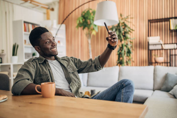 istock Young man relaxing at home and using mobile phone 1495360974