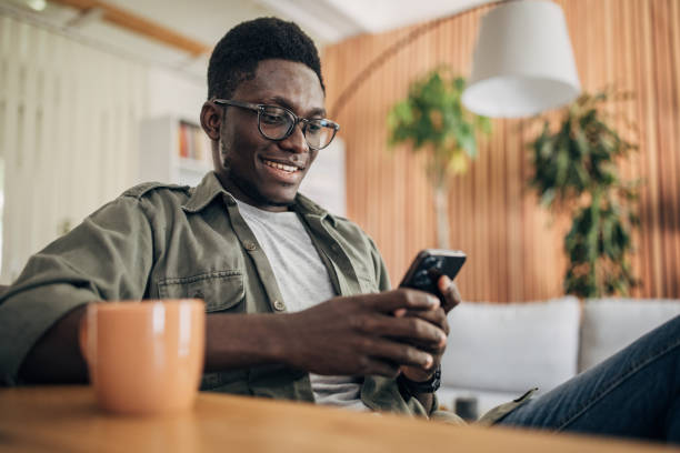istock Young man relaxing at home and using mobile phone 1495361201