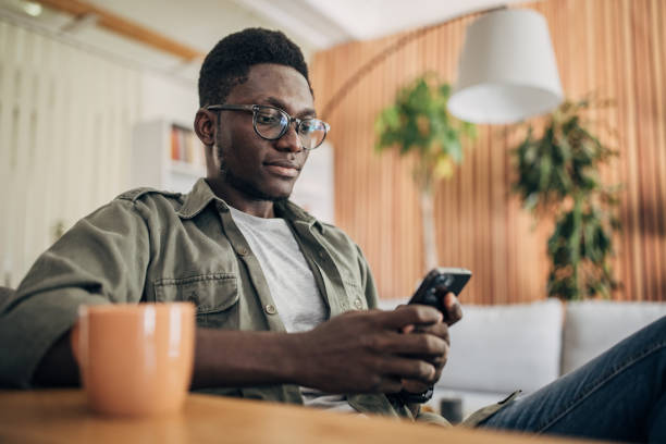 istock Young man relaxing at home and using mobile phone 1495361253