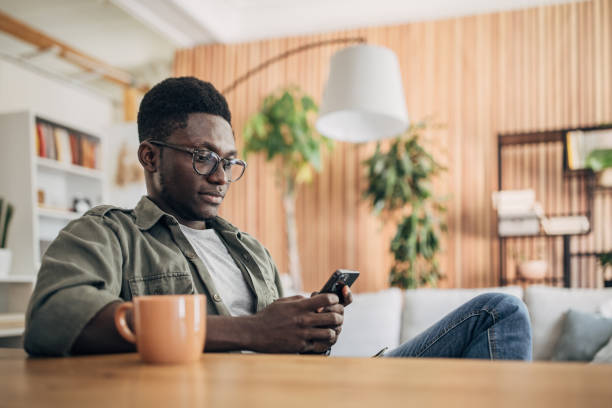istock Young man relaxing at home and using mobile phone 1495361307
