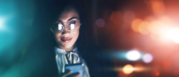 istock Businesswoman, phone and communication at night for texting, chatting or networking on dark background. Female employee smile holding smartphone working late for online planning strategy on mockup 1495366834
