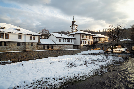 Scenic view before sunset with old houses covered with snow in the revival architectural complex in Tryavna, Bulgaria