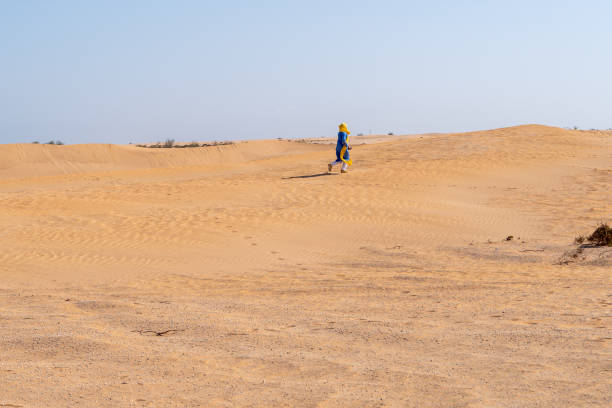istock Man walks in the desert under a blue sky 1495370564