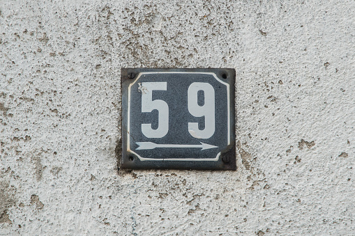 Weathered grunge square metal enameled plate of number of street address with number 59