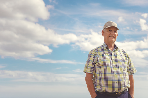Portrait of a proud senior farmer infront of the sky