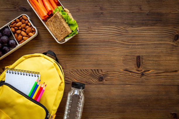 istock Healthy school lunch box with fruits and backpack, top view 1495380855