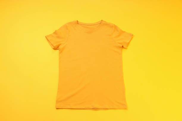 istock Orange t-shirt with space for print on yellow background 1495381907