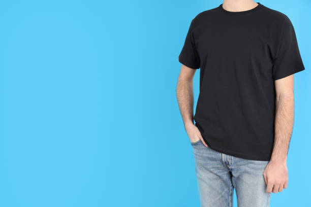 istock Man in blank black t-shirt on blue background 1495382090