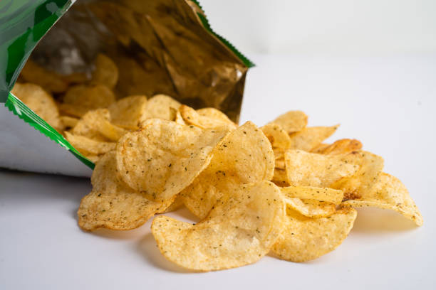 istock Potato chips, delicious spicy for crips, thin slice deep fried snack fast food in open bag. 1495386932