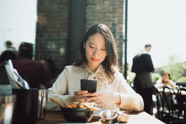 istock Beautiful Asian woman using a smartphone in a restaurant. 1495388524