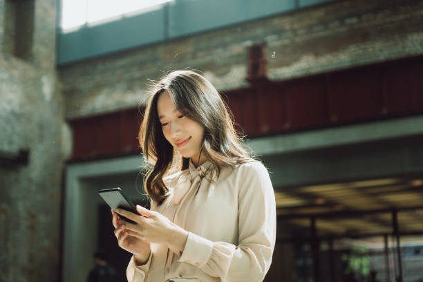 istock Beautiful Asian woman using a smartphone inside a hall 1495388910