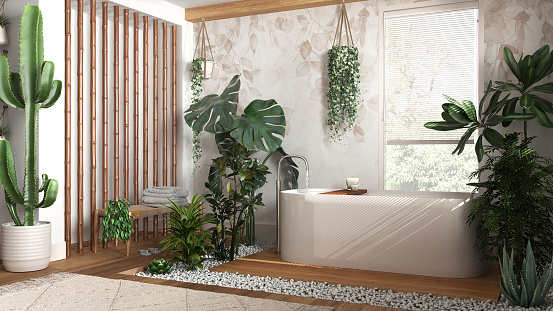 Modern wooden bathroom in white and beige tones with freestanding bathtub and bamboo wall. Biophilic concept, many houseplants. Urban jungle interior design