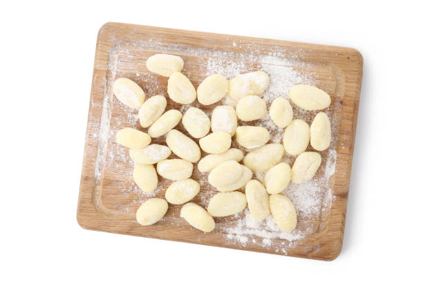 istock Board with raw potato gnocchi isolated on white background 1495390185