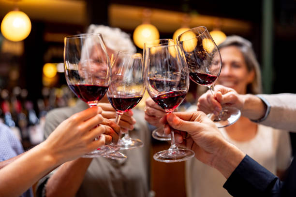happy group of people making a toast at a wine tasting - winetasting imagens e fotografias de stock