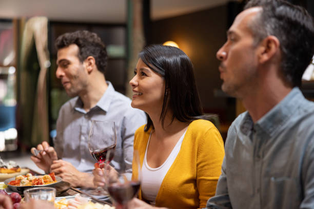 istock Woman having dinner at a restaurant with some friends 1495390790