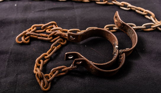 Criminal hand with handcuffs on black background. The scene is situated in controlled studio environment in front of black background. Photo is taken with SONY AIII camera.
