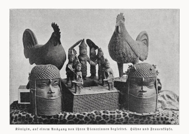 Various Benin bronzes, halftone print, published in 1899 Queen accompanied on an excursion by her servants. Roosters and women's heads - components of looted art (Benin bronzes), which were sold to Germany, among others, in the course of the colonization of Africa by the United Kingdom in 1897. The Benin Bronzes are a group of several thousand metal plaques and sculptures that decorated the royal palace of the Kingdom of Benin, in what is now Edo State, Nigeria. Collectively, the objects form the best examples of Benin art and were created from the thirteenth century by artists of the Edo people. In addition to their great art-historical importance, they also play an important role in the international discussion about the return of cultural property of colonial origin. Halftone print after a photograph, published in 1899. benin head sculptures stock illustrations