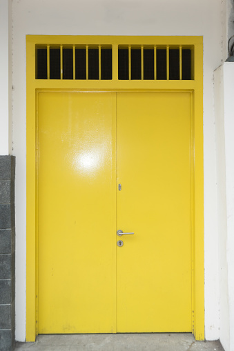 Yellow door with stone brick texture white painted wall old house