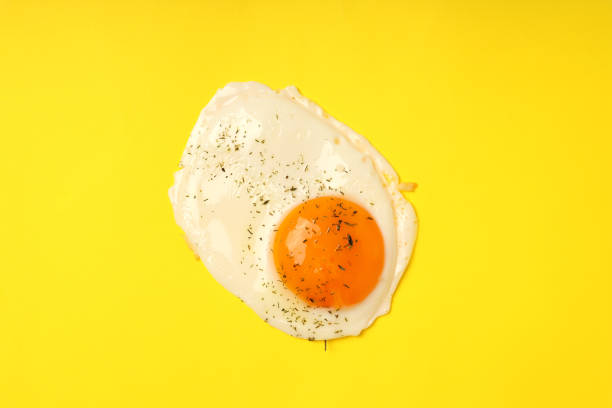 istock Fried egg with spices on yellow background, top view 1495396541