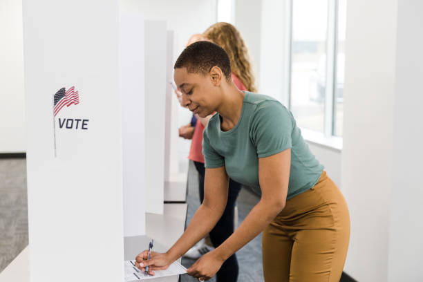 istock Diverse voters stand in row to cast ballots 1495396721