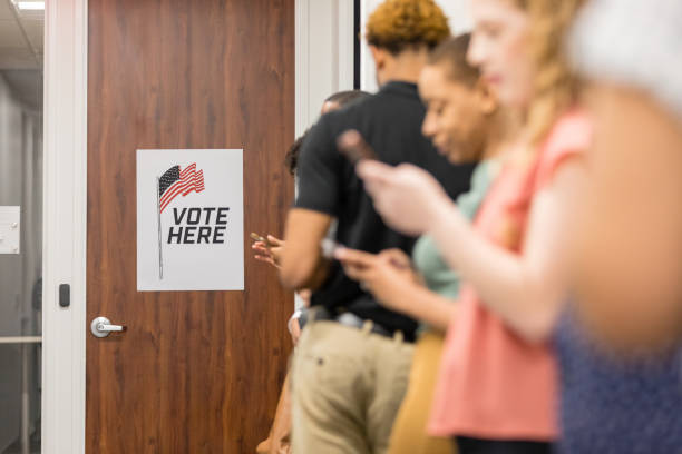 istock Multiracial group uses phones while waiting to vote 1495396732