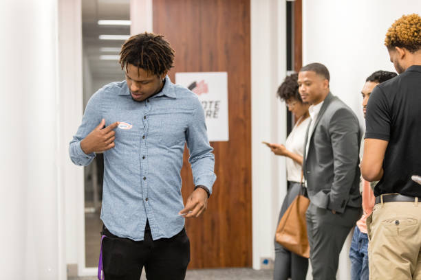 istock Leaving polling place, young man touches 'I voted' sticker 1495396735