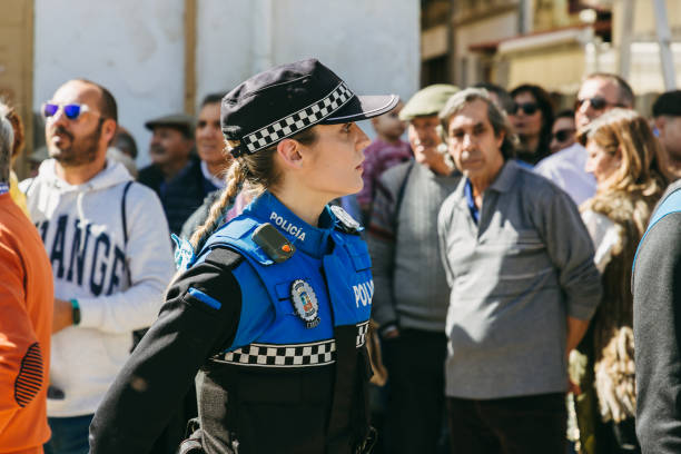 A policewoman keeps order during the local city holiday. El Espinar, Spain - March 12, 2023: A policewoman keeps order during the local city holiday "Gabareros". police policewoman women spain stock pictures, royalty-free photos & images