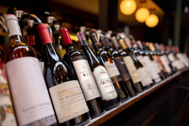 Close-up on bottles of wine displayed at a winery Close-up on bottles of wine displayed on the rack at a winery - wine culture concepts wine bottle stock pictures, royalty-free photos & images