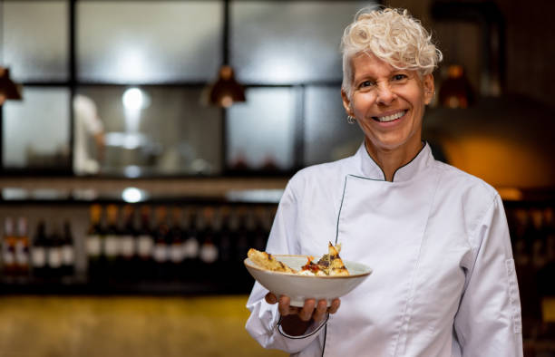 istock Happy chef holding a plate at a fine dining restaurant 1495400818