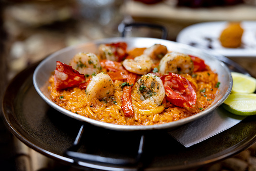 Close-up on delicious paella served at a Spanish restaurant - food and drinks establishment concepts