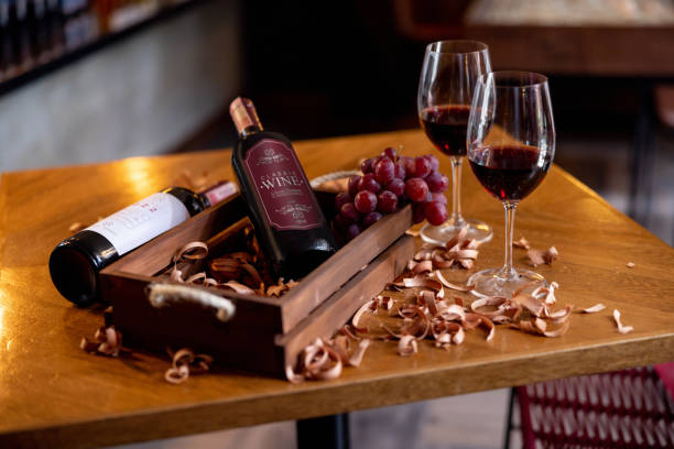 hermosa exhibición minorista que muestra botellas de vino tinto junto a copas - wine wine rack liquor store bar fotografías e imágenes de stock