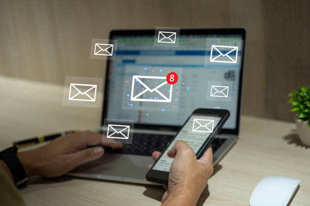 istock Businessman using laptop and mobile smartphone with email notification alert on virtual screen. 1495404049