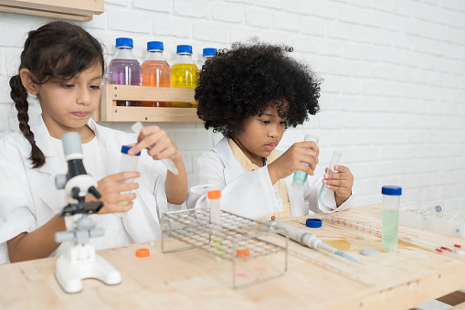 Group of child girl learning science and analyse liquid in the laboratory at school. Science and education, researcher and discovery concept