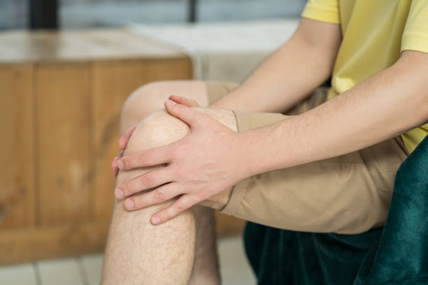 istock Knee pain, man suffering from ache and doing self-massage at home 1495405971