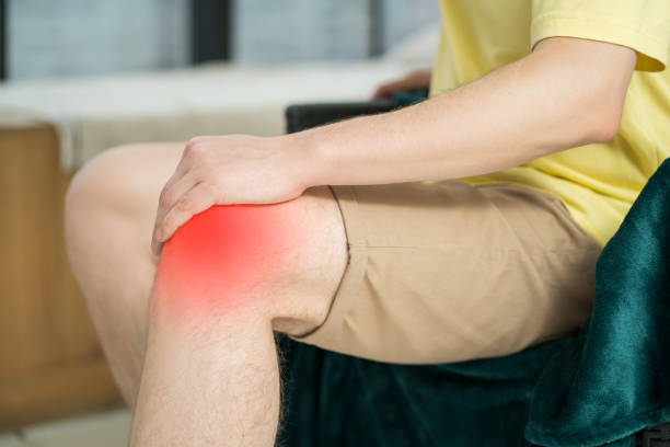 istock Knee pain, man suffering from ache and doing self-massage at home 1495406283