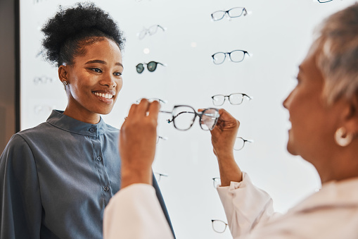 Vision, optician and black woman shopping for glasses in optometry store or shop for ophthalmology. Doctor, healthcare and happy female or medical ophthalmologist with eyewear or lenses for eye care.