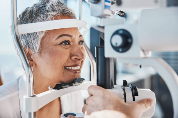 Face, eye exam or happy woman in test or consulting doctor for eyesight at optometrist or ophthalmologist. Senior customer testing vision with optician helping or testing iris or retina visual health cara, examen de la vista o mujer feliz en prueba o médico consultor para la evaluación de la vista en el consultorio del optometrista. cliente senior que prueba la visión con un óptico que ayuda o verifica la salud visual del iris o la retina