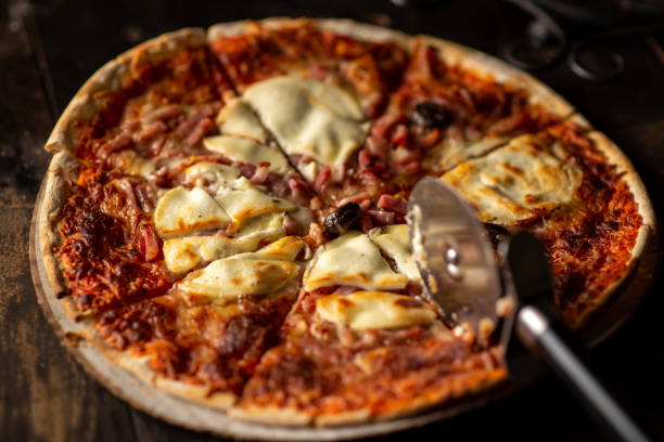 istock Freshly cooked pizza. Cut into pieces. Dark background. Close-up. 1495408076
