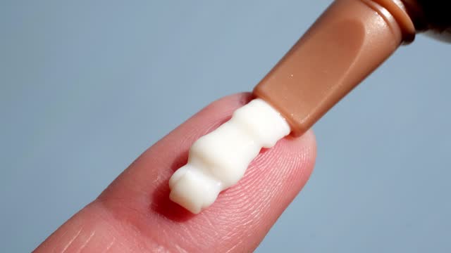 Applying cream from a tube on a finger close-up